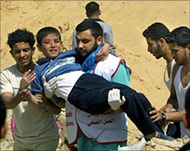 A Palestinian paramedic carries a wounded child to safety