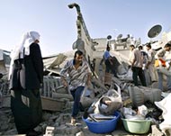 Refugees check the damage to their home after a missile strike