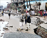 Kashmiris survey a shattered street after an avalanche