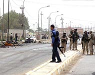 US soldiers and Iraq police at thecar-bombing site in Baquba