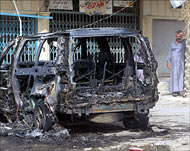 Iraqis gather at the scene of acar bomb in southern Baghdad