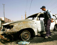 An Iraqi police car lies burnt out in the Baya district of Baghdad