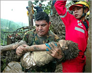A soldier carries the body of a child killed in the storm 