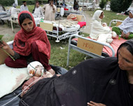 Relatives sit with injured victimsoutside a hospital in Abbottabad