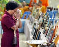 A Thai woman prays for family members who died