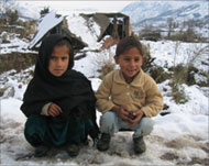 Numan and Nazia sit near theremains of a house in Battal