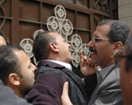 Men calm the son (C) of Noshi Atta Girgis, who was killed Friday