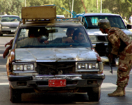 An Iraqi soldier searches a car at a checkpoint in central Baghdad 