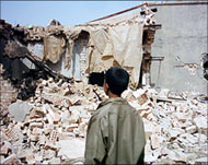 A boy stands outside a destroyed house in Ishaqi (file photo)
