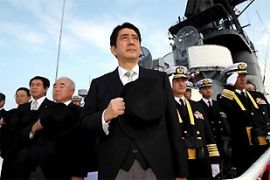 Japanese prime minister Shinzo Abe salutes aboard a navy vessel