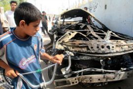 Boy looks at car bomb in Iraq
