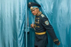Kazakh soldier leave polling booth