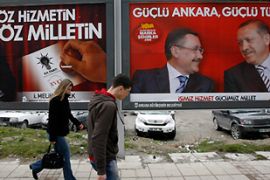 People walk past campaign billboards ahead of Sunday''s municipal elections, in Ankara