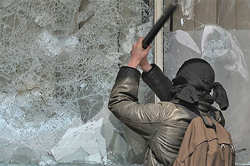 FRANCE, Strasbourg : An anti-NATO demonstrators smashes a window in Strasbourg on April 4, 2009 during the NATO summit. A violent demonstration against a NATO summit in Strasbourg attracted 30,000 protestors, organisers said, while local officials put the number at 10,000. AFP PHOTO / FREDERIC FLORIN