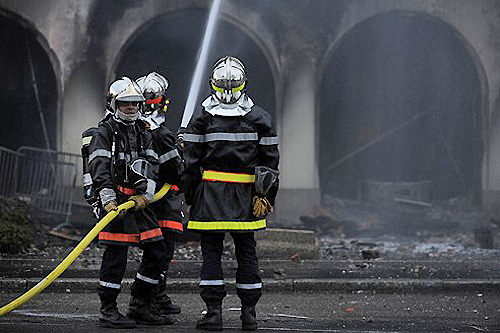 FRANCE, Strasbourg : Firemen douse the burnt remains of a hotel that caught fire during violent clashes between anti-NATO protesters and riot police in Strasbourg on April 4, 2009. A violent demonstration against a NATO summit in Strasbourg attracted 30,000 protestors, organisers said, while local officials put the number at 10,000. AFP PHOTO / JOHN MACDOUGALL