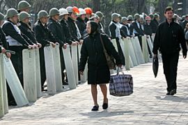 Moldovans walk past police guarding the presidential building in Chisinau
