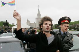 Policeman leads away a gay rights activist during an unsanctioned gay rights protest in Moscow