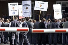 shows employees of German luxury sportscar manufacturer Porsche demonstrating against a possible merger of their company with Europe''s biggest carmaker Volkswagen