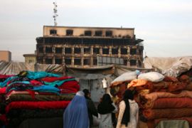 Afghans buy clothes at burnt out shopping mall
