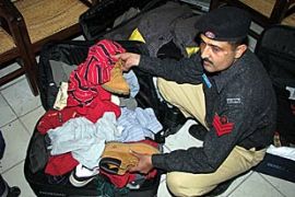 A Pakistani police official inspects luggage in Karachi allegedly belonging to arrested US Muslims in Sargodha, about 160km west of Lahore
