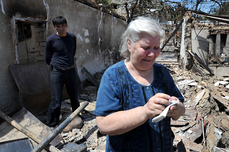 520 - Osh, -, KYRGYZSTAN : An Ethnik Uzbek woman cries as she stands beside the wreckage of her burned out home in Osh on June 14, 2010. Deadly gun battles raged in the Kyrgyzstan city of Osh where bodies littered the streets as ethnic violence escalated and Uzbekistan raced to cope with a massive refugee influx. AFP PHOTO / VICTOR DRACHEV