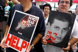 Protesters hold up posters of captured soldier Gilad Shalit