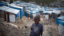 A boy stands amidst tents in Haiti