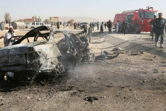 Afghans inspect destroyed car of slain deputy governor