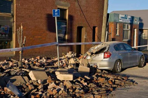Quake-damaged car and building are seen in Christchurch
