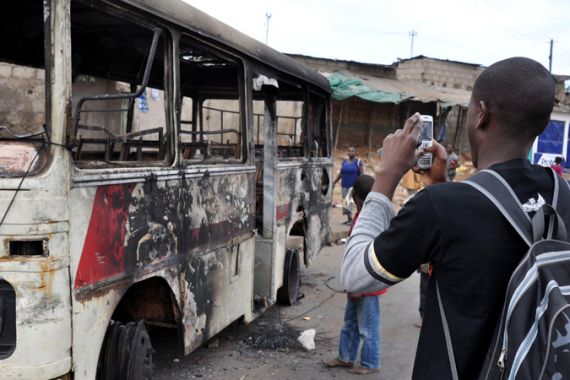 Mozambican takes a picture of a burnt out bus after food price riots