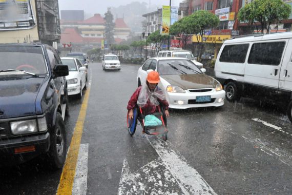 Man in wheelchair navigates traffic during Philippines typhoon