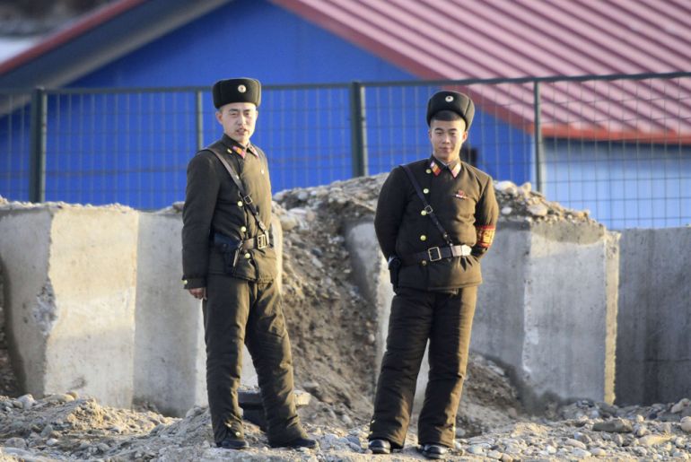 North Korean soldiers stand guard on banks of Yalu River, near North Korean town of Sinuiju, opposite Chinese border city of Dandong