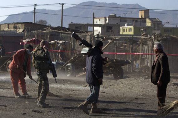 Afghan policeman keeps watch at a suicide bomb attack site in Kabul