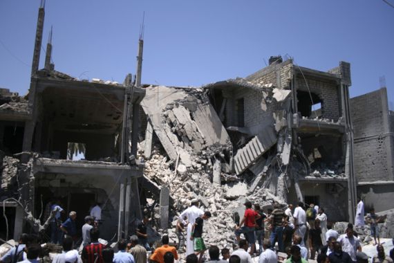 People inspect the rubble of a residential building, which Libyan officials say was hit by a NATO air strike