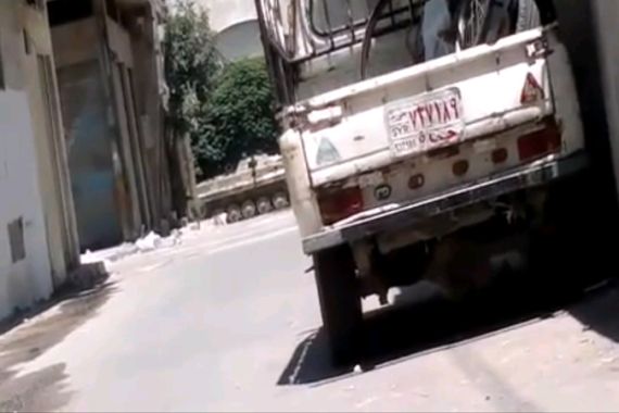 An armored car patrols a street in Homs, Syria