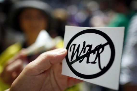 A woman hands out anti-war decals during an anti-nuclear weapons protest rally and march in New York