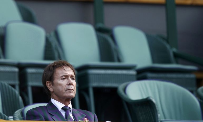 Singer Cliff Richard sits on Centre Court at the Wimbledon tennis championships in London