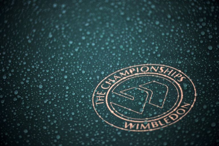 A rain drenched umbrella featuring the Wimbledon logo.