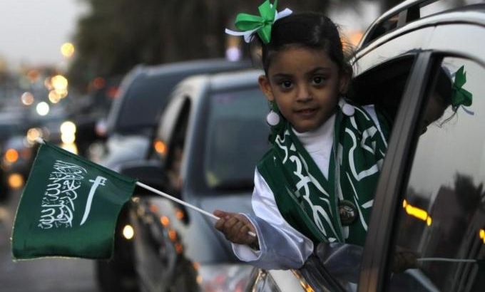 A girl waves a Saudi national flag after Saudi King Abdullah addressed the nation in Riyadh