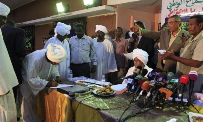 A supporter from Sudan''s main opposition parties signs a document requesting for democratic alternatives to the one-party rule in Omdurman