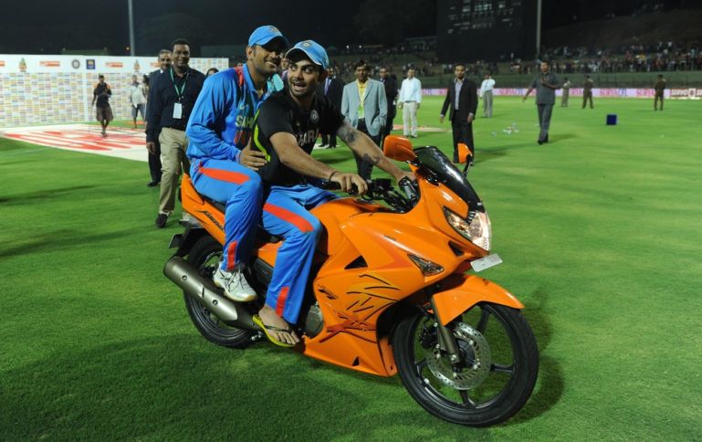 Indian cricketer Virat Kohli (R) sits wi
