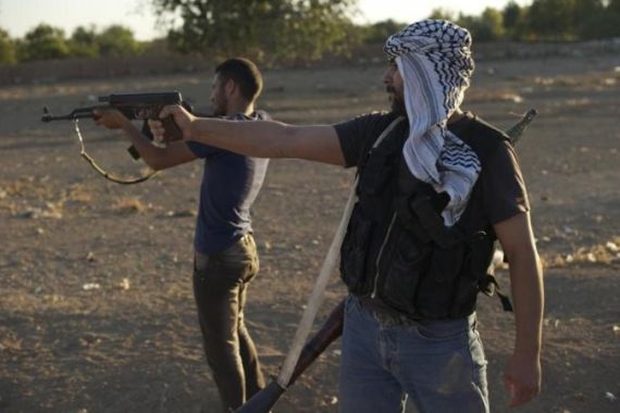 Syrian rebel fighters shoot during targe