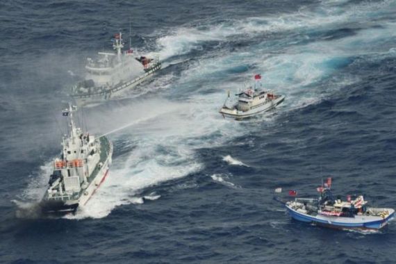 An aerial view shows Japan Coast Guard patrol ship spraying water at fishing boats from Taiwan as Taiwan''s Coast Guard vessel sails near the disputed islands in the East China Sea