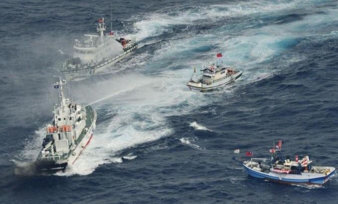An aerial view shows Japan Coast Guard patrol ship spraying water at fishing boats from Taiwan as Taiwan''s Coast Guard vessel sails near the disputed islands in the East China Sea