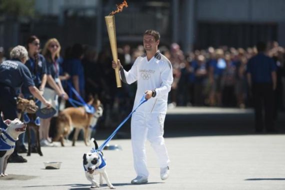 Former England striker Michael Owen carries the Olympic Torch through Battersea dogs home with a Staffordshire Bull Terrier called Rory in London