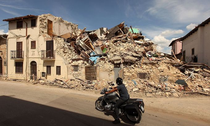 motorbike in front of earthquake damage in Italy