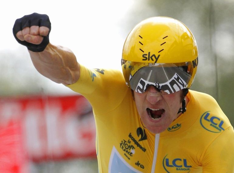 Sky Procycling rider and leader''s yellow jersey Wiggins of Britain holds up his arm as he crosses the finish line during the individual time trial of the 19th stage of the 99th Tour de France cycling race between Bonneval and Chartres