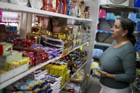 A woman looks for her groceries at a supermarket in Caracas