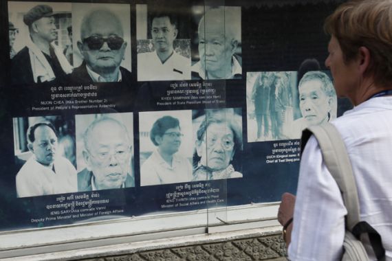 A tourist looks at portraits of former Khmer Rouge leaders on display at Tuol Sleng Genorcide Museum