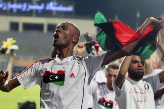 Libya''s Ahmed Saad celebrates with teammates with a Kingdom of Libya flag after wining against Mozambique during their 2012 African Cup of Nations qualifying soccer match in Cairo